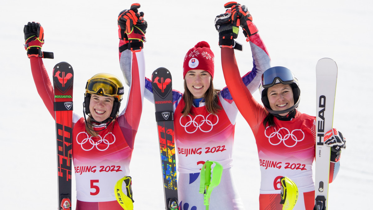 Az aranyérmes szlovák Petra Vlhova (k), az ezüstérmes osztrák Katharina Liensberger (b) és a bronzérmes svájci Wendy Holdener a női műlesiklók versenyének eredményhirdetésén a 2022-es pekingi téli olimpián, a jencsingi zónában lévő Nemzeti Alpesisí Központban 2022. február 9-én.