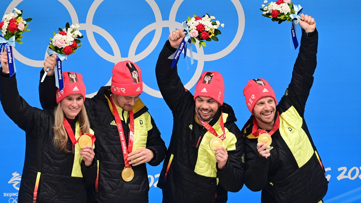 Az aranyérmes német Natalie Geisenberger, Johannes Ludwig, Tobias Arlt és Tobias Wendl (b-j) a 2022-es pekingi téli olimpia szánkó vegyesváltójának díjátadóján a jencsingi zónában lévő Hsziaohajte Bob- és Szánkópályán 2022. február 10-én.