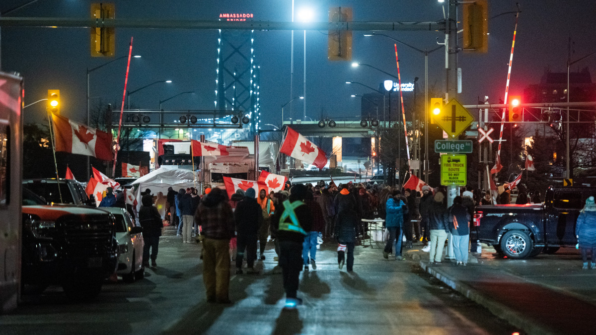 Protesters wave Canadian flags while blocking access to the Ambassador Bridge during a demonstration in Windsor, Ontario, Canada, on Friday, Feb. 11, 2022. The premier of Canadas biggest province declared a state of emergency, warning protesters who are blocking a key border crossing and causing gridlock in the Canadian capital that they face severe consequences if they dont leave. Photographer: Galit Rodan/Bloomberg via Getty Images