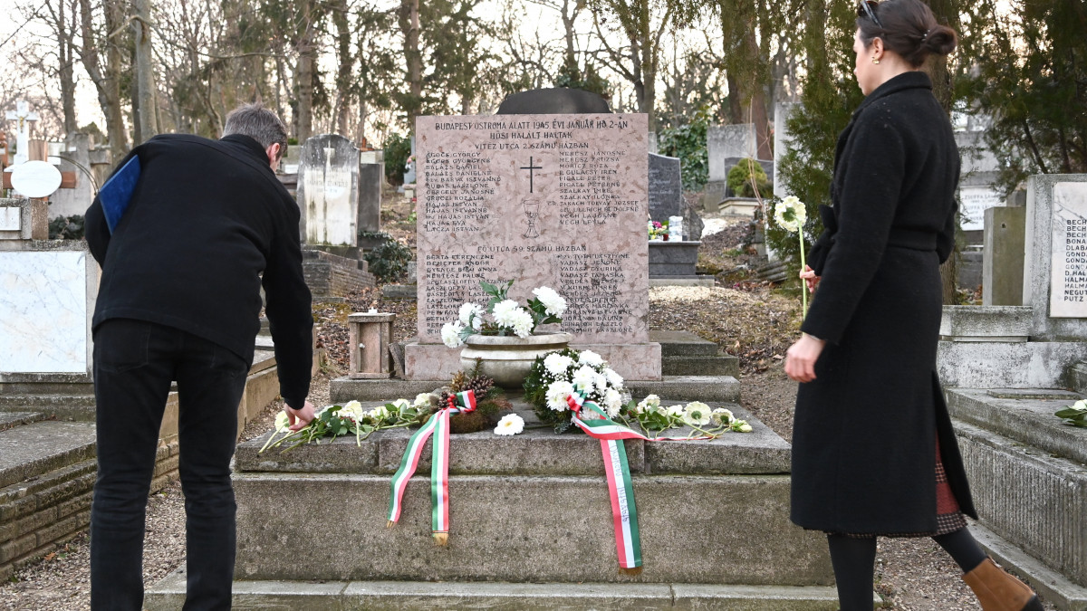 Résztvevők virágot helyeznek el a Vitéz u. 2. és a Fő u. 59. szám alatti sarokházakban hősi halált halt áldozatok síremlékénél a Budapest 77 évvel ezelőtt véget ért ostromának civil áldozatairól tartott megemlékezésen a Farkasréti temetőben, az áldozatok síremlékeinél 2022. február 13-án. A megemlékezést a Nemzeti Örökség Intézete szervezte. 
