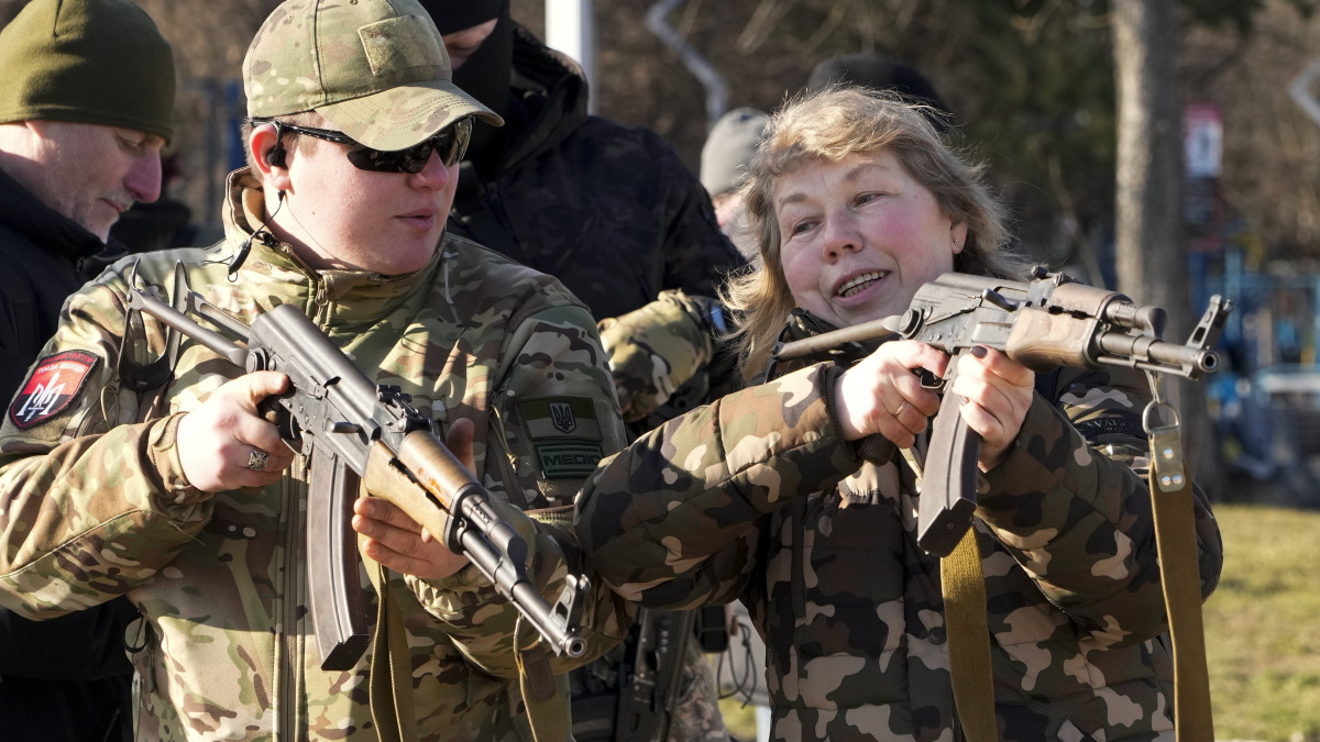 Kalasnyikov gépfegyverrel tanítanak lőni egy asszonyt Kijevben 2022. február 13-án. A Nyugat azzal vádolja Oroszországot, hogy több mint százezer katonát vonultatott fel az ukrán határon invázióra készülve. Moszkva tagadja, hogy meg akarná támadni nyugati szomszédját.