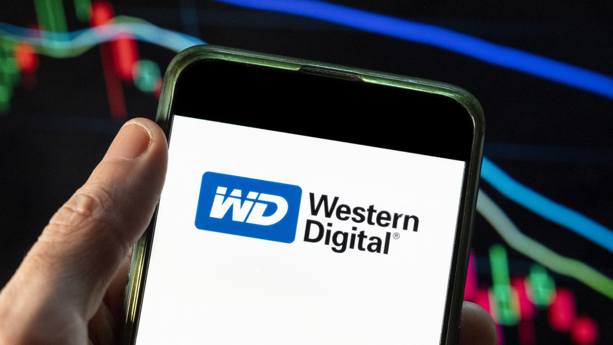 CHINA - 2021/12/09: In this photo illustration the American computer hard disk drive and data storage manufacturer Western Digital (WD) logo seen displayed on a smartphone with an economic stock exchange index graph in the background. (Photo Illustration by Budrul Chukrut/SOPA Images/LightRocket via Getty Images)