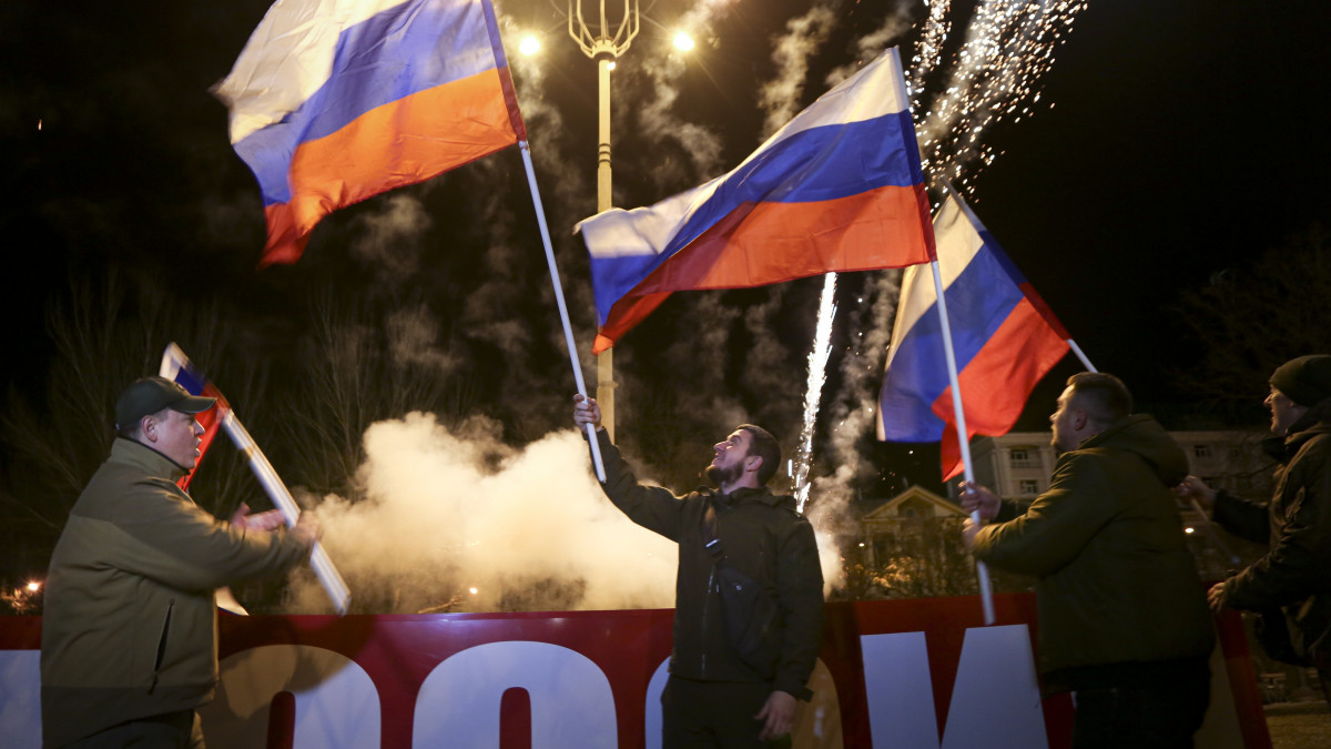 Orosz zászlókkal és tűzijátékkal ünnepelnek emberek Donyeck belvárosában 2022. február 21-én, miután Vlagyimir Putyin orosz elnök aláírta a két önhatalmúlag kikiáltott délkelet-ukrajnai szakadár terület - a Luhanszki Népköztársaság és a Donyecki Népköztársaság - függetlenségének elismeréséről szóló dokumentumot.
