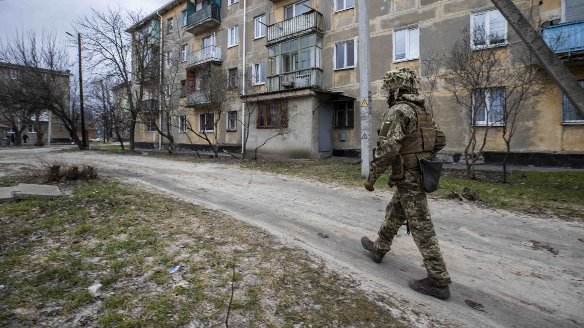LUHANSK, UKRAINE - FEBRUARY 22: A soldier is seen in front of a building damaged by bullets and cannon balls at Schastia town of Luhansk as tension rises after RussiaĂ˘s recognition of UkraineĂ˘s breakaway regions in Luhansk, Ukraine on February 22, 2022. (Photo by Aytac Unal/Anadolu Agency via Getty Images)