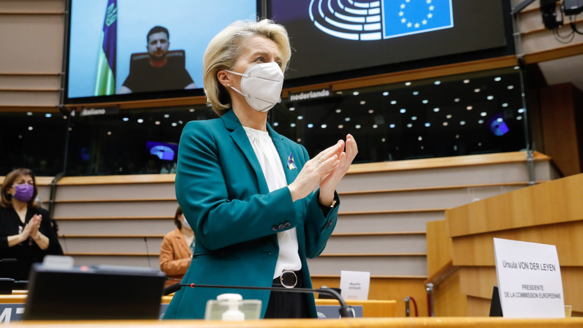 Ursula von Der Leyen, az Európai Bizottság elnöke (k) tapsol, miközben Volodimir Zelenszkij ukrán elnök (a kivetítőn) részt vesz az Európai Parlament rendkívüli plenáris ülésén Brüsszelben 2022. március 1-jén. Vlagyimir Putyin orosz elnök február 24-én rendelte el katonai művelet végrehajtását Ukrajnában.