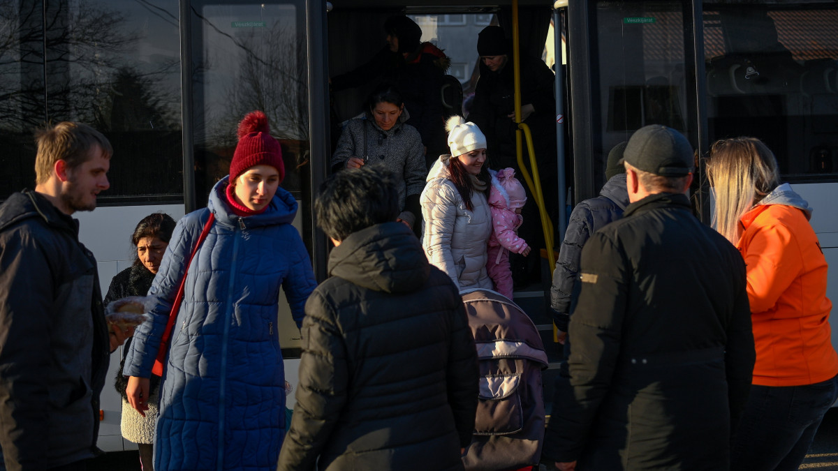 Az orosz-ukrán háború elől menekülő emberek leszállnak a buszról, amellyel a helyi határátkelőhelytől szállították őket a tiszabecsi II. Rákóczi Ferenc Általános Iskolához 2022. február 28-án. Az intézmény tornaterméből ideiglenes szálláshelyet alakítottak ki a menekültek számára. 