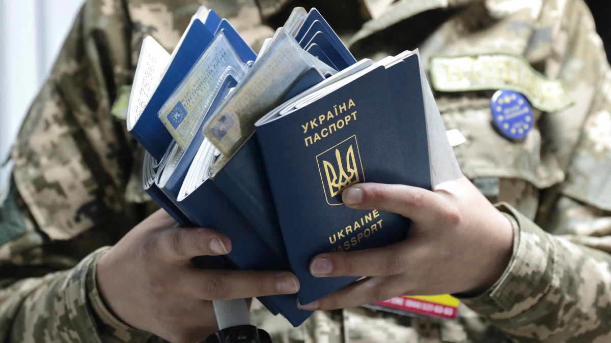 Lviv, 2017. június 11.Útleveleket ellenőriz egy ukrán határőr az ukrán-lengyel határ Rava-Ruska átkelőhelyén, az ukrajnai Lviv közelében 2017. június 11-én. Ezen a napon életbe lépett az ukrán állampolgárok európai uniós vízummentessége, Ukrajna biometrikus útlevéllel rendelkező állampolgárai ezentúl vízum nélkül utazhatnak az Európai Unió tagállamaiba. (MTI/EPA/Pavlo Palamarcsuk)