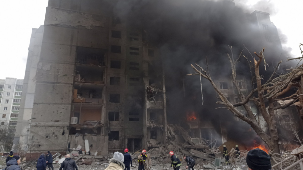 Tűzoltók dolgoznak a lángok megfékezésén egy orosz légicsapásban kigyulladt épületnél az észak-ukrajnai Csernyihiv központjában 2022. március 3-án. Vlagyimir Putyin orosz elnök február 24-én rendelte el katonai művelet végrehajtását Ukrajnában.