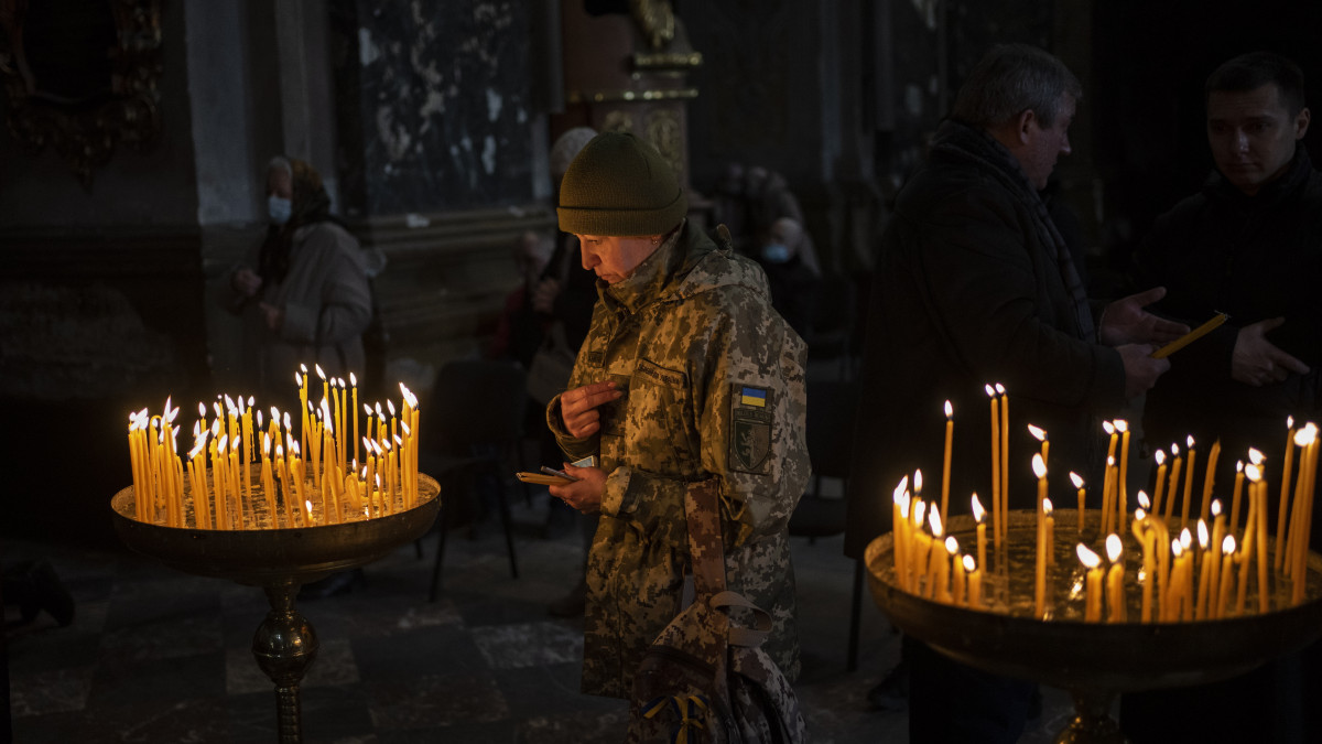 Katonaruhába öltözött ukrán nő imádkozik a Szent Péter és Pál-templomban a nyugat-ukrajnai Lvivben 2022. március 6-án. Vlagyimir Putyin orosz elnök február 24-én rendelte el katonai művelet végrehajtását Ukrajnában.