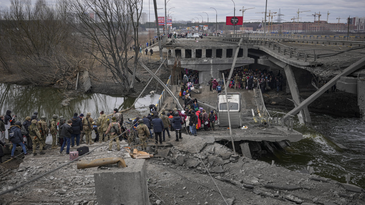 Orosz légicsapásban lerombolt híd alatt épített átjárón menekülnek emberek a Kijev közelében lévő Irpinyben 2022. március 5-én. Vlagyimir Putyin orosz elnök február 24-én rendelte el katonai művelet végrehajtását Ukrajnában.