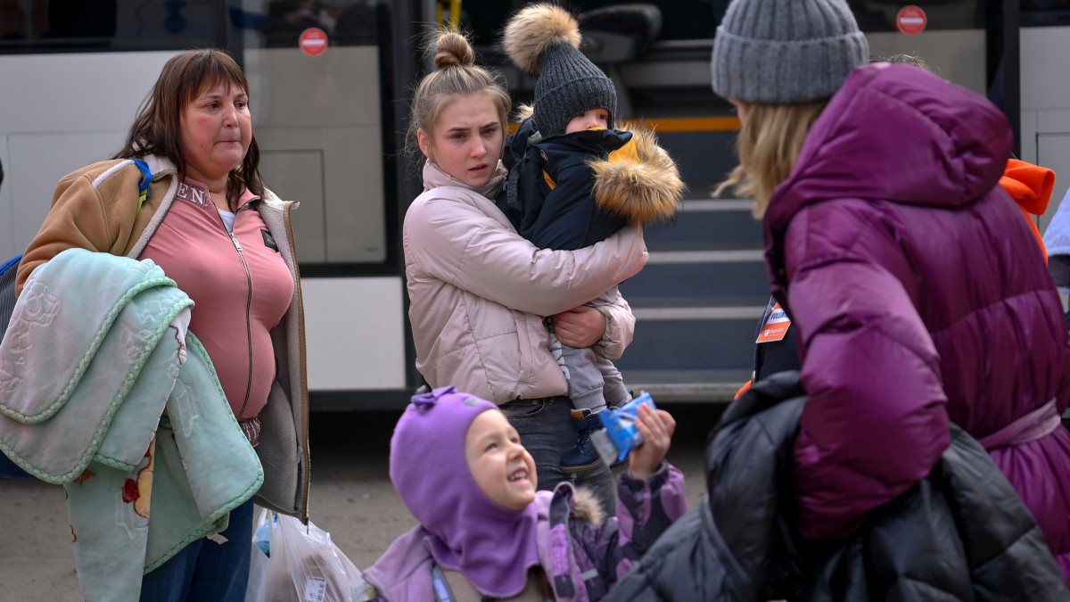 Az orosz-ukrán háború elől Ukrajnából menekülő emberek szállnak le a buszról, amellyel a tiszabecsi II. Rákóczi Ferenc Általános Iskolánál kialakított segítségponthoz szállították őket a helyi határátkelőhelytől 2022. március 4-én.