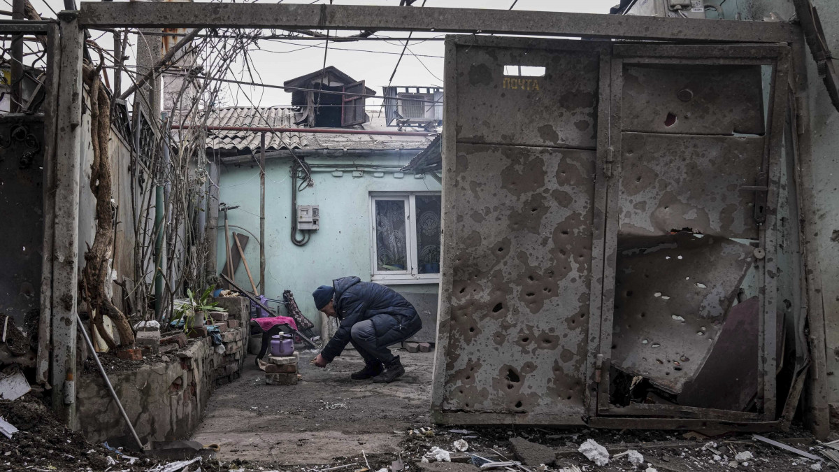 Tüzet gyújt egy férfi egy tüzérségi támadás miatt megrongálódott ház romjai között Mariupolban 2022. március 7-én. Vlagyimir Putyin orosz elnök február 24-én rendelte el katonai művelet végrehajtását Ukrajnában.