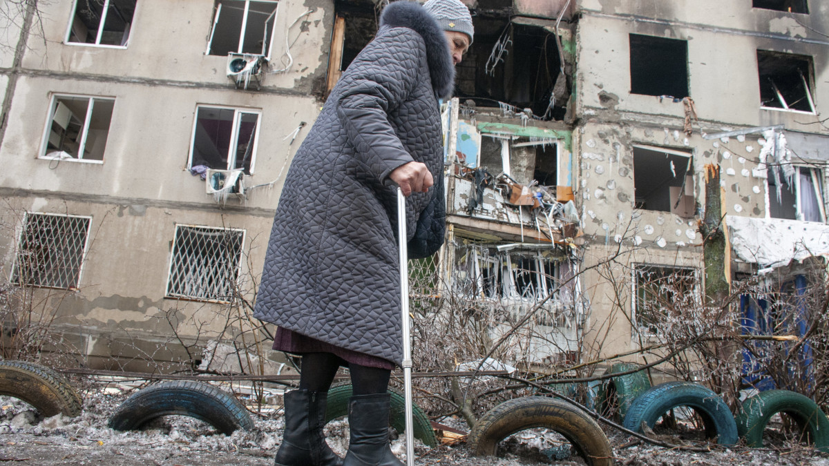 Idős nő megy egy tüzérségi támadásban megsemmisült társasház előtt Harkivban 2022. március 8-án. Vlagyimir Putyin orosz elnök február 24-én rendelte el katonai művelet végrehajtását Ukrajnában.