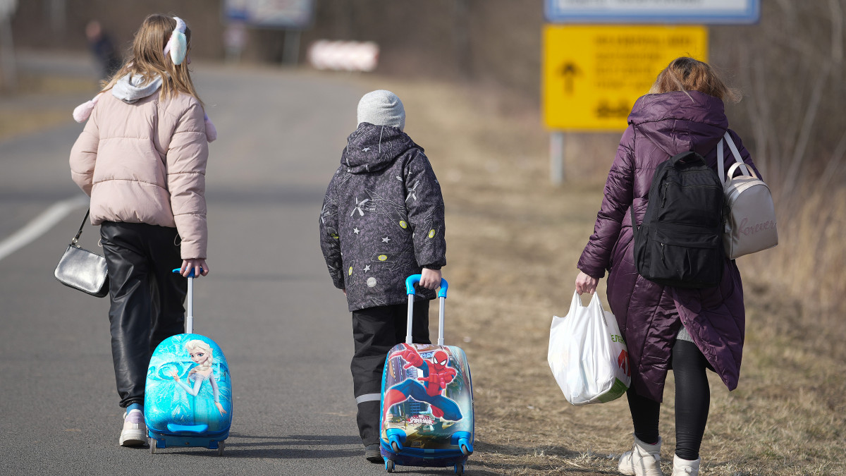LONYA, HUNGARY - MARCH 03: A family of Ukrainian refugees walk along the road after walking across the border at the Hungarian town of Lonya on March 03, 2022 in Lonya, Hungary. Over one million refugees from Ukraine have now fled into neighbouring countries such as Hungary, forming long queues at border crossings, after Russia began a large-scale attack on Ukraine on February 24, 2022.  (Photo by Christopher Furlong/Getty Images)