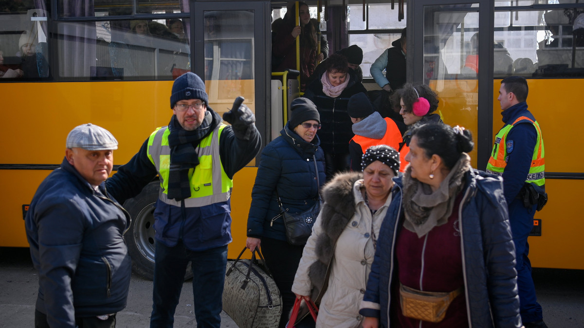 Az orosz-ukrán háború elől Ukrajnából menekülő emberek szállnak le a buszról, amellyel a tiszabecsi II. Rákóczi Ferenc Általános Iskolánál kialakított segítségponthoz szállították őket a helyi határátkelőhelytől 2022. március 10-én.