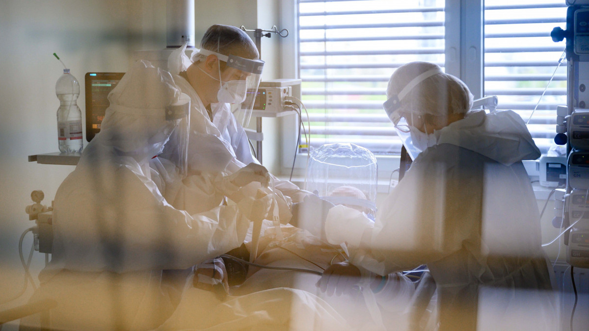 Védőfelszerelést viselő orvos és ápolók egy oxigénellátást segítő helmet sisakot helyeznek fel egy betegre a koronavírussal fertőzött betegek fogadására kialakított központi intenzív osztályon a Fejér Megyei Szent György Egyetemi Oktató Kórházban, Székesfehérváron 2021. április 28-án.