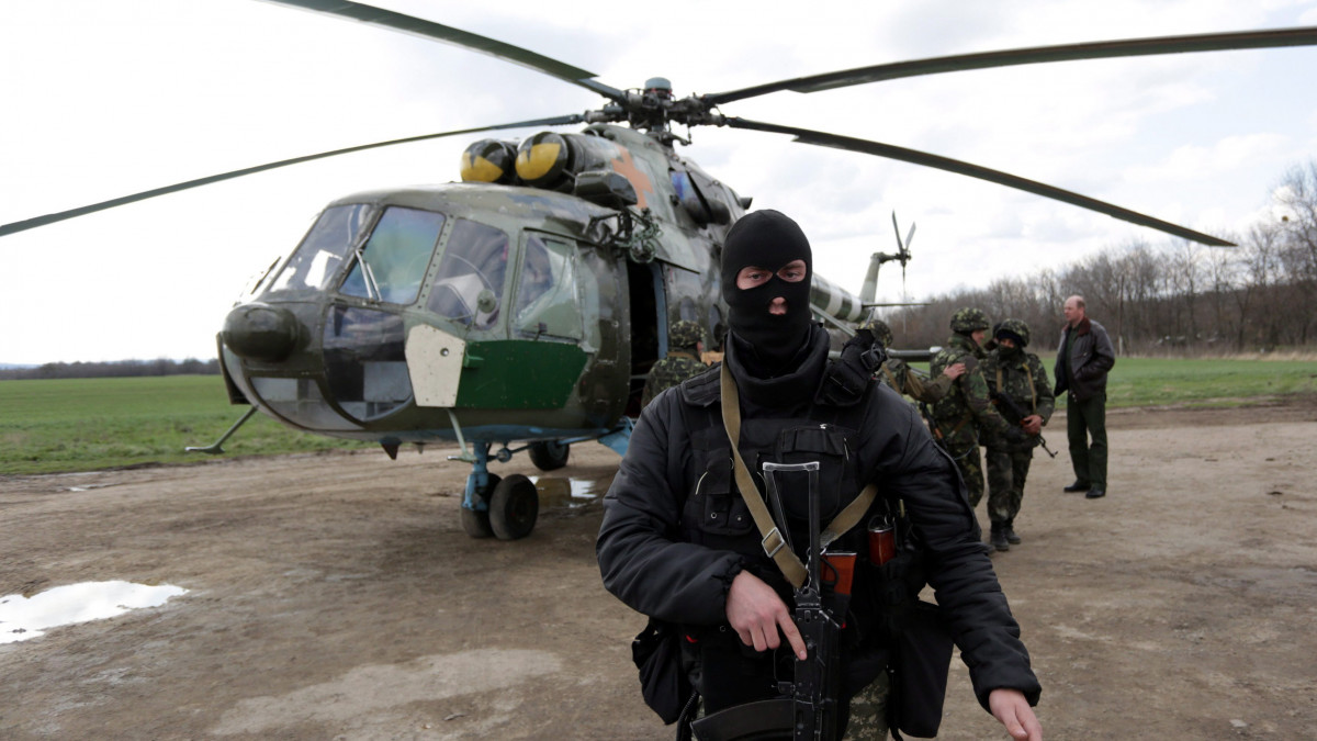 Ukrán katonák egy katonai helikopter mellett a kelet-ukrajnai Izjumban 2014. április 15-én. A kelet-ukrajnai városokban oroszbarát szakadárok foglalták el a közigazgatás épületeit.