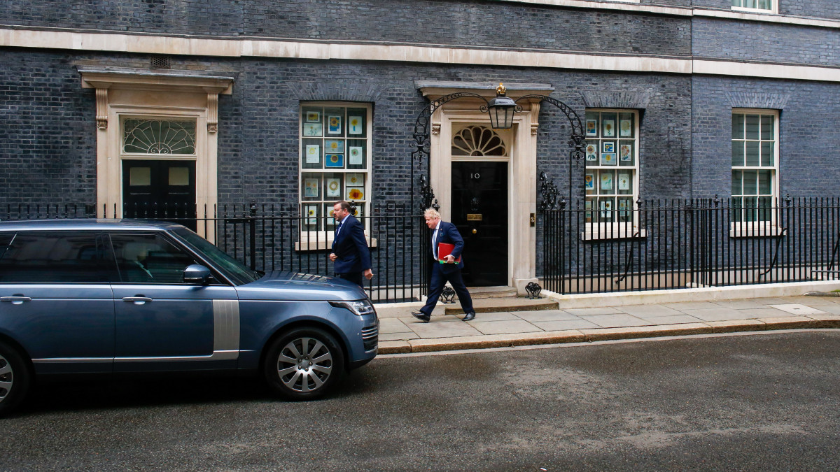 Boris Johnson, U.K. prime minister, right, departs from number 10 Downing Street to attend a weekly questions and answers session at Parliament in London, U.K., on Wednesday, March 30, 2022. Johnson, dubbed a greased piglet by a predecessor for his ability to get out of a tight political spot, appears to have won over critics from his own Conservative Party through his handling of the war in Ukraine. Photographer: Hollie Adams/Bloomberg via Getty Images