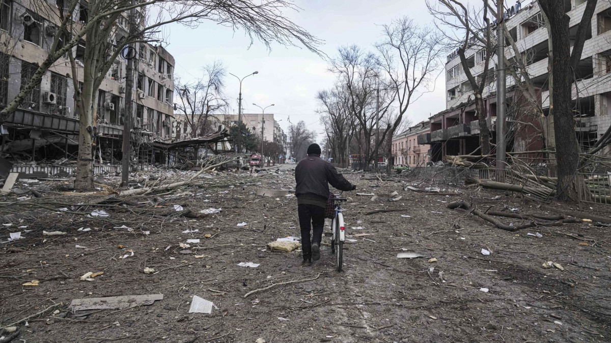 Megrongálódott lakóépületek romjai között tolja kerékpárját egy férfi a délkelet-ukrajnai Mariupolban2022. március 10-én. Vlagyimir Putyin orosz elnök február 24-én rendelte el katonai művelet végrehajtását Ukrajnában.