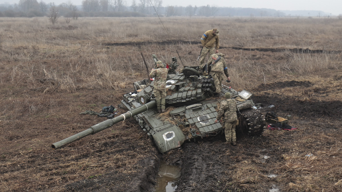 Ukrán katonák vizsgálják egy megsemmisült orosz páncélozott harci jármű roncsát a Kijev megyében fekvő és az ukrán hadsereg által visszafoglalt Nova Baszanban 2022. április elsején.