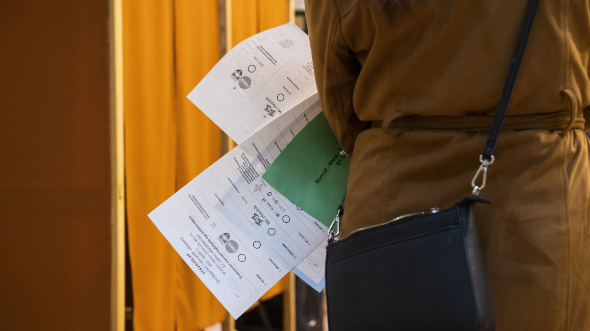 Egy nő vár, hogy beléphessen a szavazófülkébe a nyíregyházi Vasvári Pál Gimnáziumban az országgyűlési választáson és gyermekvédelmi népszavazáson 2022. április 3-án.