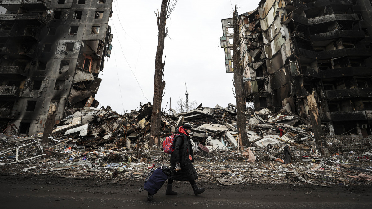 Borodianka, Ukrajna, 2022. április 5. - Ukrán nő sétál a megrongálódott épületek romjain. A település hetekig heves összecsapások színhelye volt. Az ukrán csapatok már visszavették az uralmat a város felett.Forrás: Metin Aktas/Anadolu Agency via Getty Images