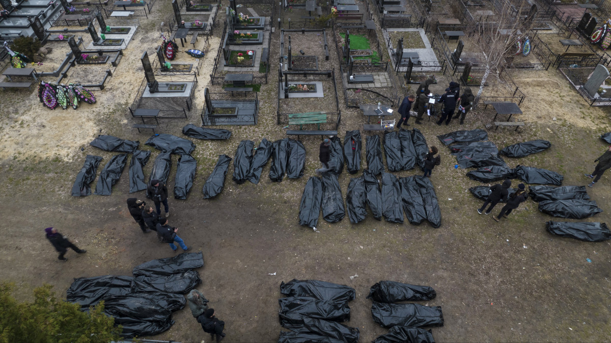 Civilek nejlonzsákban lévő holttesteinek azonosítását végzik rendőrök és hatósági személyek a Kijev melletti Bucsában 2022. április 6-án, mielőtt egy kijevi halottasházba szállítanák őket. Az ukrán hatóságok napokkal ezelőtt Kijev környékén készült fényképeket és videófelvételeket tettek közzé, amelyeken számos, utcán fekvő, civil ruhás ember holtteste látható. Az orosz kormány ukrán szélsőségesek provokációjának minősítette a történteket.