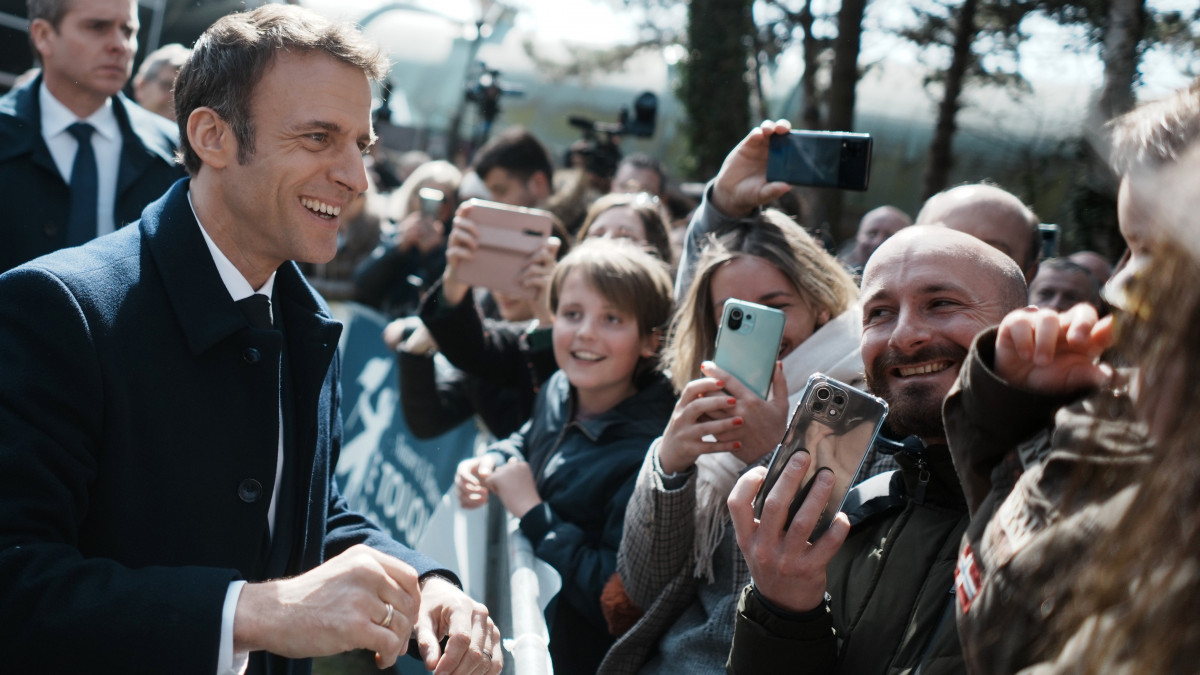 Emmanuel Macron francia elnök (b) a helyi lakosokkal beszélget, miután leadta voksát a francia elnökválasztás első fordulójában az észak-franciaországi Le Touquet egyik  szavazóhelyiségében 2022. április 10-én.