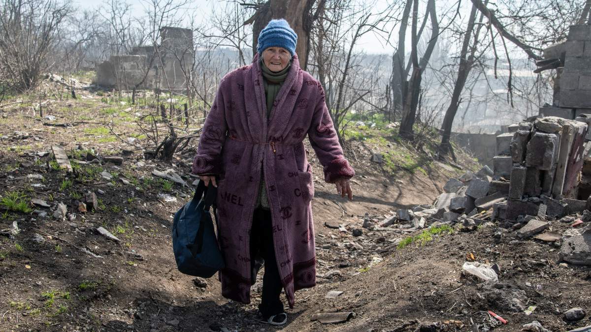 MARIUPOL, UKRAINE - 2022/04/09: A woman walks on a hill leading down to the Azov Sea in the southern area of Mariupol. The battle between Russian / Pro Russian forces and the defending Ukrainian forces led by the Azov battalion continues in the port city of Mariupol. (Photo by Maximilian Clarke/SOPA Images/LightRocket via Getty Images)