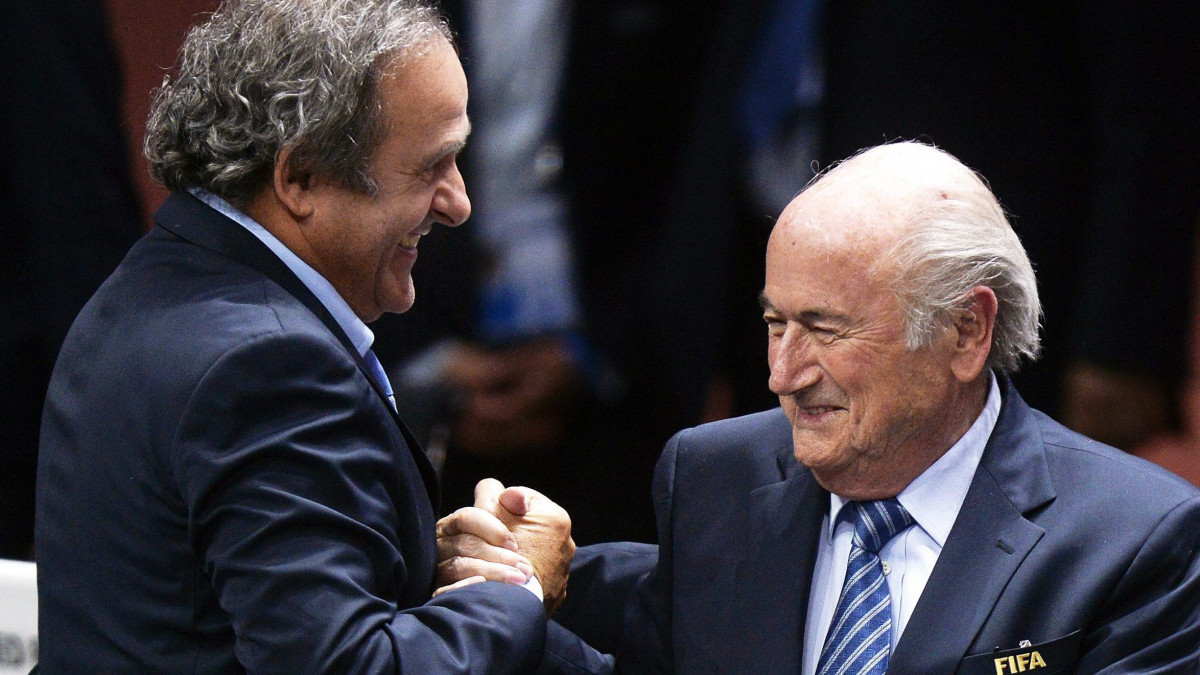 Joseph Blatter, a Nemzetközi Labdarúgó-szövetség, a FIFA elnöke (j) és Michel Platini, az Európai Labdarúgó-szövetség, az UEFA elnöke kezet fog Zürichben 2015. május 29-én. A FIFA etikai bizottsága 2015. október 8-án ideiglenesen, kilencven napra felfüggesztette a korrupciós botrányba került Joseph Blatter FIFA-elnököt, Michel Platini UEFA-elnököt, és Jerome Valcke főtitkárt.