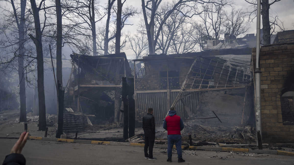A fosztogatók által felgyújtott éttermük maradványait nézik a tulajdonosok a Kijev közelében lévő Bucsában 2022. április 11-én.