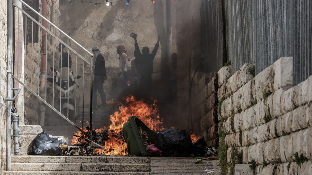 17 April 2022, Israel, Jerusalem: Palestinians set fire to a rubbish bin during clashes with Israeli security forces in the old city of Jerusalem. Photo: Ilia Yefimovich/dpa (Photo by Ilia Yefimovich/picture alliance via Getty Images)