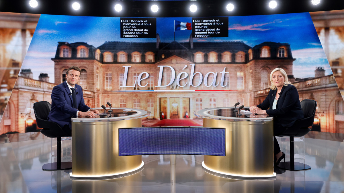 Emmanuel Macron francia elnök (b) és Marine Le Pen, a francia ellenzéki Nemzeti Tömörülés párt vezetője az elnökjelöltek televíziós vitájának kezdetén a Párizs közelében fekvő La Plaine-Saint-Denis településen 2022. április 20-án, négy nappal a francia elnökválasztás második fordulója előtt.