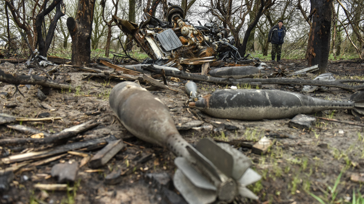 Az orosz támadások után ott maradt bombák maradványait nézi egy férfi a Csernyihivi területen fekvő Ivanyivkában 2022. április 20-án.