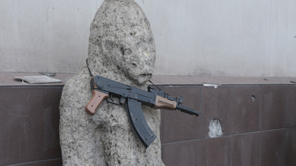 Játékfegyver lóg egy kiállított tárgyon a mariupoli helytörténeti múzeumban 2022. áprili 28-án.