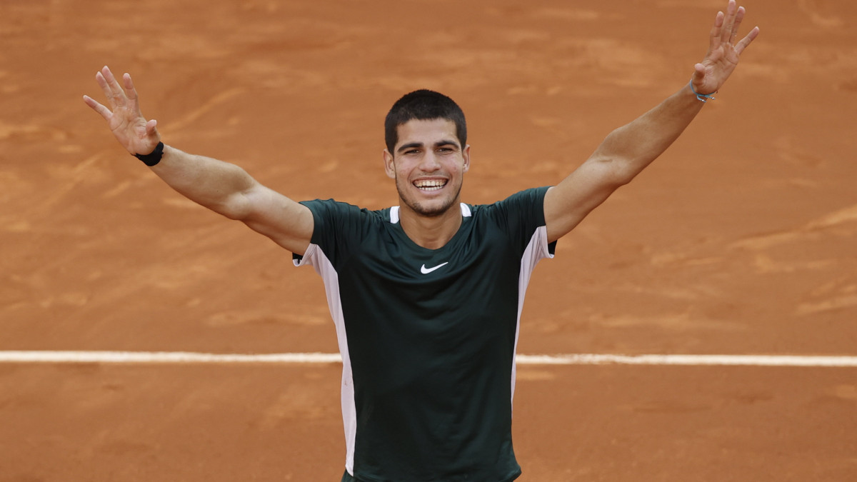 A 19 éves spanyol Carlos Alcaraz ünnepel, miután  6:7 (5-7), 7:5, 7:6 (7-5) arányban legyőzte a világelső szerb Novak Djokovicot a madridi salakpályás tenisztorna férfi versenyének elődöntőjében 2022. május 7-én.