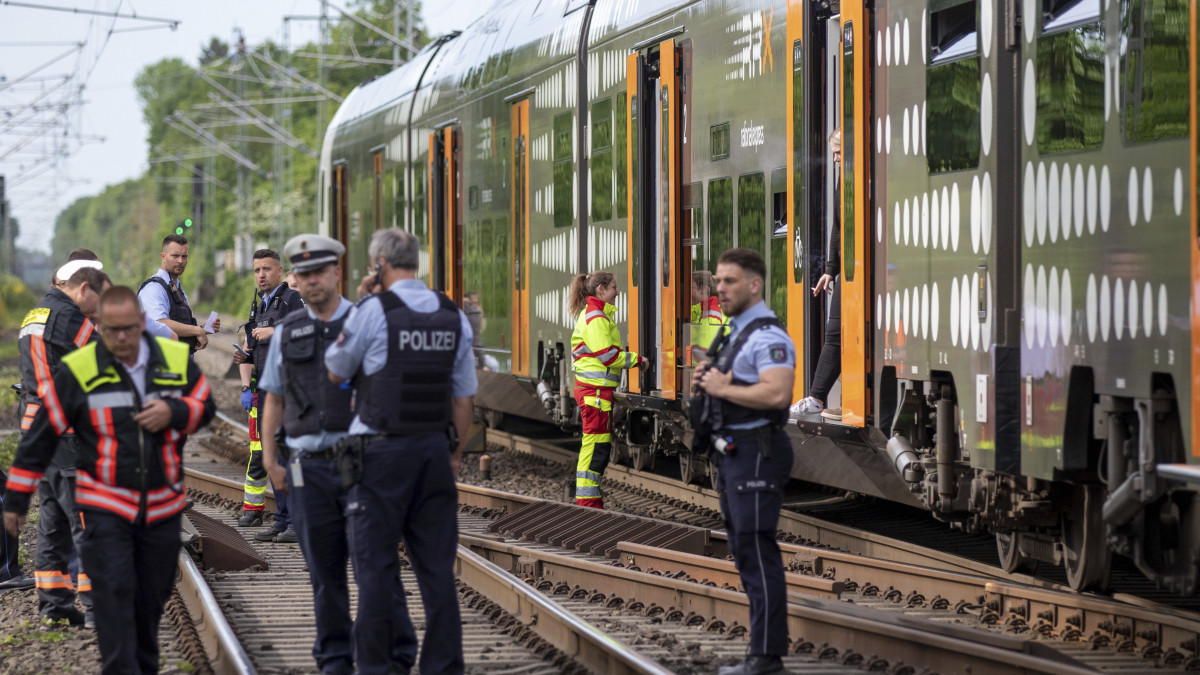 Rendőrök állnak a Mönchengladbachból Aachenbe tartó, 4-es számú regionális expresszvonat előtt Herzogenrathban 2022. május 13-án. Korábban egy iraki menekült férfi késes támadást követett el a vonaton. A támadás során hat embert megsebesítült, köztük a feltételezett elkövető.