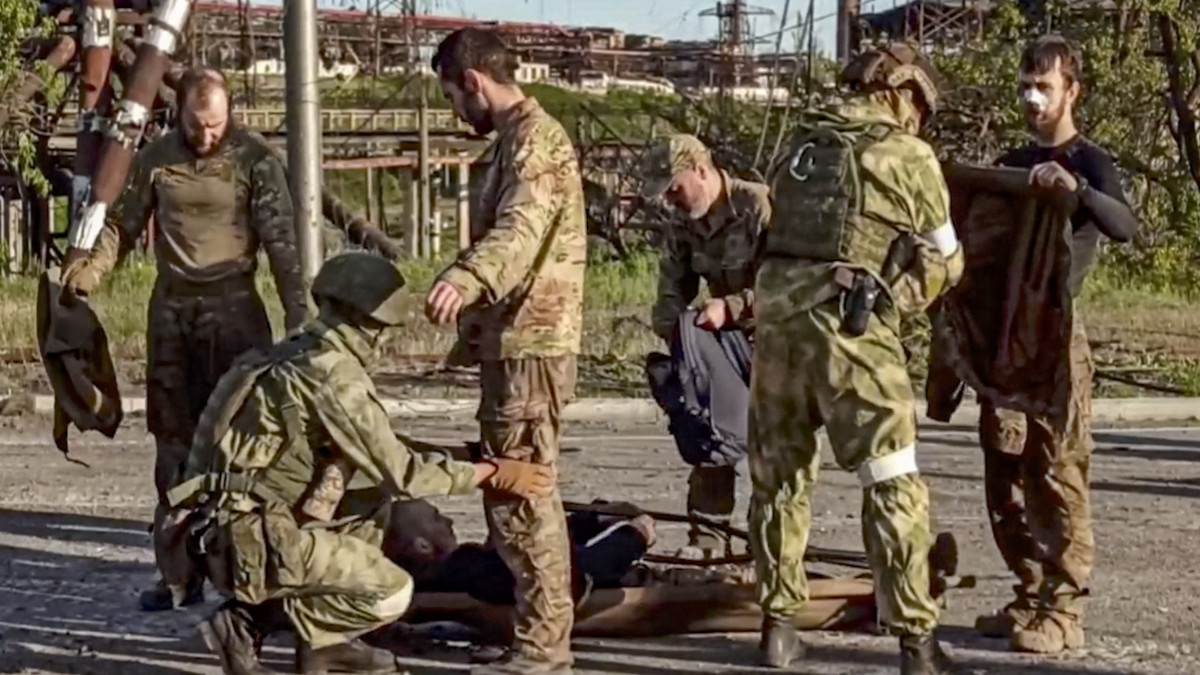 Az orosz védelmi minisztérium sajtószolgálata által videófelvételről készített képen orosz katonák ukrán katonákat kutatnak át a mariupoli Azovsztal acélmű területén 2022. május 17-én. A nap folyamán több mint 260 ukrán harcos - sokan közülük sebesültek - hagyhatta el az acélmű területét.