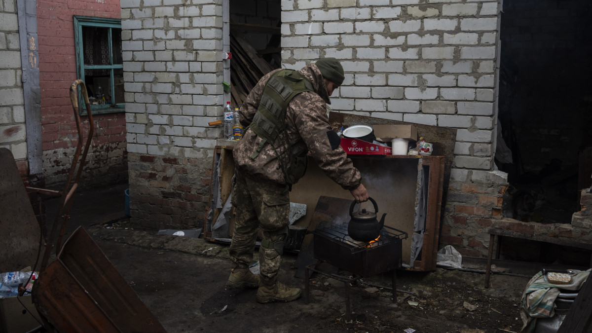 Vizet forral rögtönzött tábori konyhájában egy ukrán katona a kelet-ukrajnai Derhacsiban 2022. május 15-én.