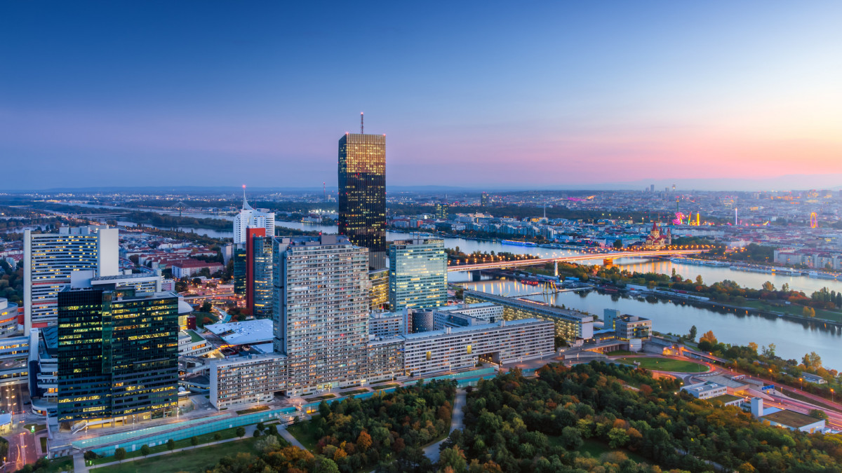Aerial view of KaisermĂźhlen business and finance district in the evening with Danube river canals, public parks and skyline of Vienna city