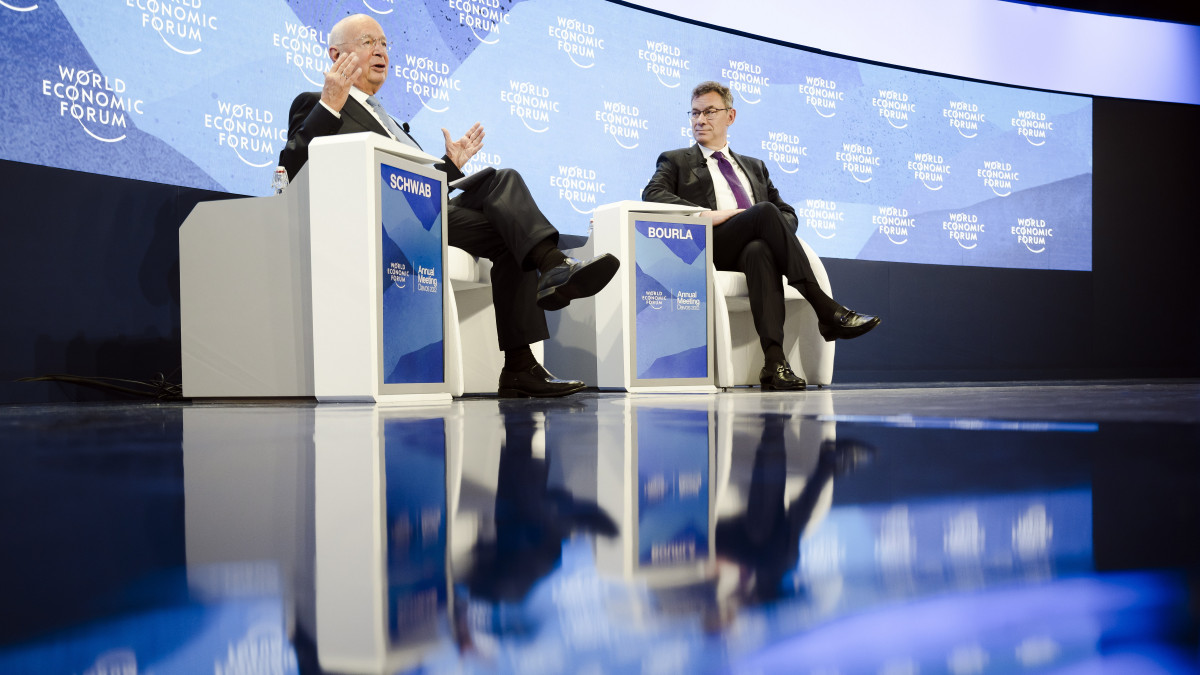 Klaus Schwab német közgazdász, a Világgazdasági Fórum alapító ügyvezető elnöke (b) és Albert Bourla, a Pfizer multinacionális gyógyszergyár vezérigazgatója plenáris ülésen vesz részt az 51. Világgazdasági Fórumon a svájci Davosban 2022. május 25-én.
