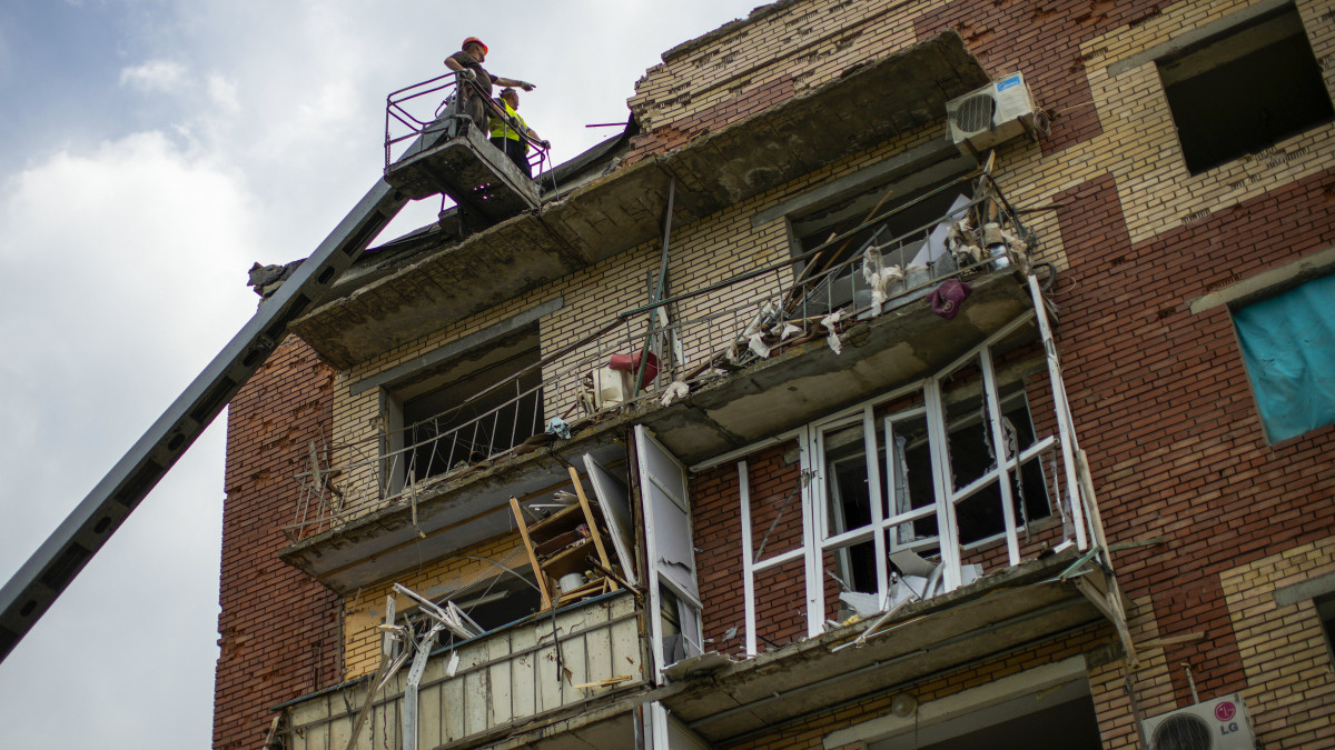 Éjszakai rakétacsapásban megrongálódott lakóépületet vizsgálnak meg a kelet-ukrajnai Szlovjanszkban 2022. május 31-én.