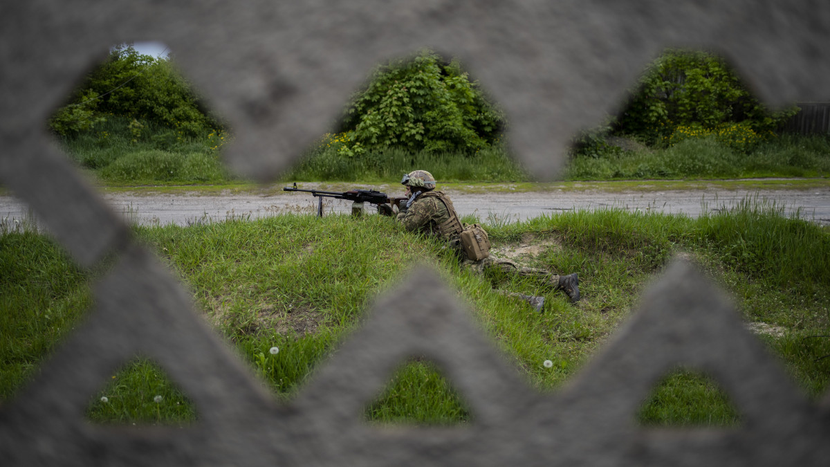 Ukrán katona egy felderítő küldetés közben az ukrán hadsereg által visszafoglalt települések egyikén, a kelet-ukrajnai Harkiv közelében 2022. május 14-én.