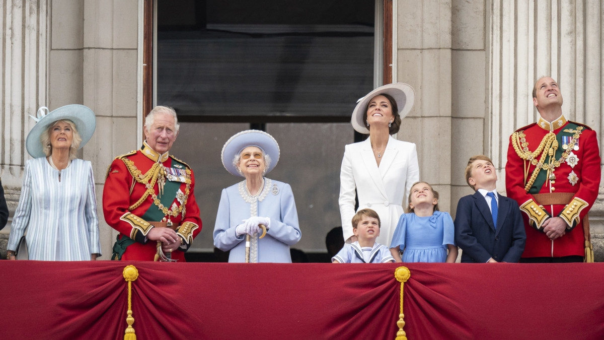 Kamilla cornwalli hercegnő, Károly walesi herceg, brit trónörökös felesége, Károly herceg, II. Erzsébet brit uralkodó, Katalin cambridge-i hercegnő, Vilmos cambridge-i herceg, a brit trónörökös elsőszülött fiának felesége, Vilmos herceg, valamint a három gyermekük, Lajos herceg, Sarolta hercegnő és György herceg (b-j) megtekinti a királynő trónra lépésének 70. évfordulója alkalmából tartott  hagyományos zászlós díszszemlét (Trooping the Colour) a londoni uralkodói rezidencia, a Buckingham-palota erkélyén 2022. június 2-án. A platinajubileum alkalmából június 2-5. között utcabálokkal és látványos parádékkal köszöntik a 96 éves királynőt, aki édesapja, VI. György király halálának napján, 1952. február 6-án lépett az Egyesült Királyság trónjára.