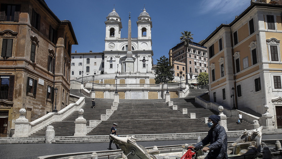 Kerékpáros halad a római Spanyol-lépcső előtt 2020. május 8-án, a koronavírus-járvány elleni védekezés második szakaszában. Olaszországban a bevezetett óvintézkedéseket fokozatosan négy fázisban oldják fel, április 27-től négy egymást követő hétfőn újabb és újabb korlátozó intézkedéseken enyhítenek.