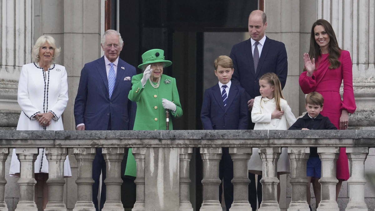 Kamilla cornwalli hercegnő, Károly walesi herceg, brit trónörökös felesége (b), Károly herceg (b2), II. Erzsébet brit uralkodó (b3), Vilmos cambridge-i herceg, a brit trónörökös elsőszülött fia (j2, hátul), Katalin cambridge-i hercegnő, Vilmos cambridge-i herceg felesége (j), valamint a három gyermekük, Lajos herceg (elöl, j3), Sarolta hercegnő (elöl, j2) és György herceg (elöl, j) a 96 éves II. Erzsébet brit királynő trónra lépése 70. évfordulójának, azaz platinajubileumának alkalmából rendezett ünnepségen a londoni Buckingham-palota erkélyén 2022. június 5-én, a négynapos rendezvénysorozat utolsó napján.