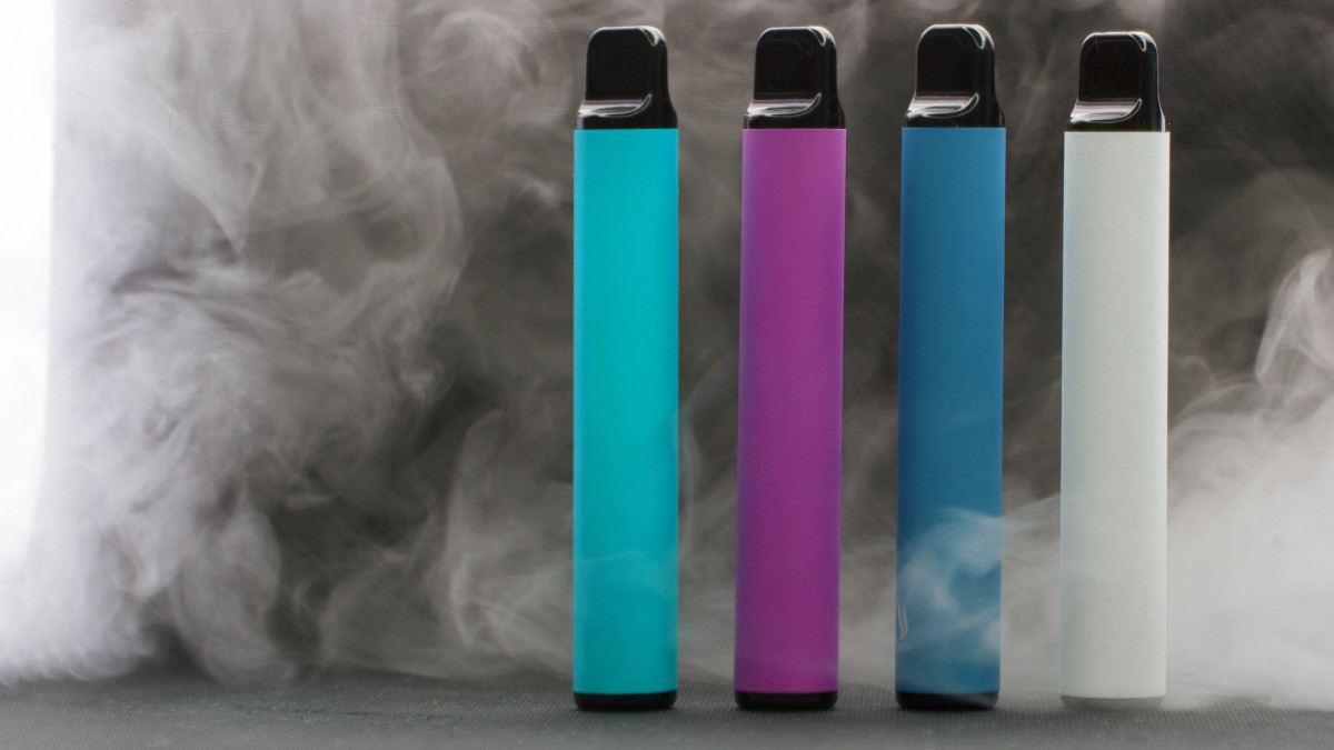 E-cigarettes on dark background in smoke, mocap, front view