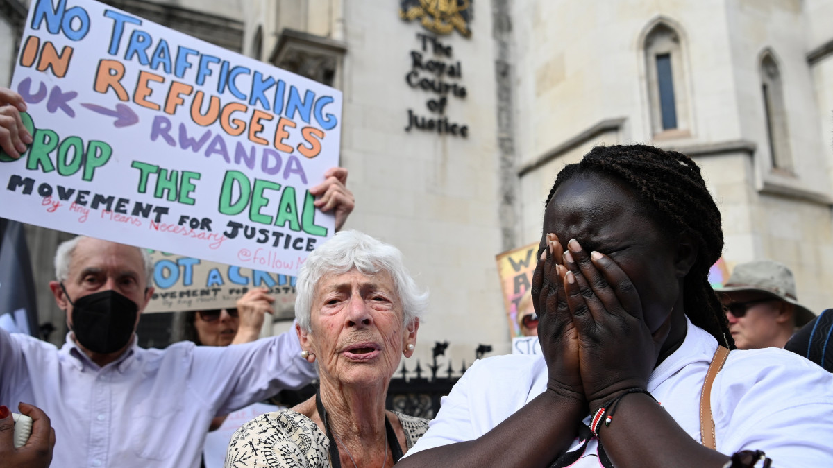 Tüntető emberjogi aktivisták a londoni fellebbviteli bíróság előtt 2022. június 13-án, miután az ítélőtábla elutasította a Nagy-Britanniába érkező illegális bevándorlók Ruandába telepítésének leállítását. A brit kormány áprilisban bejelentette, hogy egy Ruandával kötött megállapodás értelmében a közép-afrikai országba telepítik át a brit földre illegálisan érkező migránsokat. Az első csoportot a tervek szerint másnap indítják útnak.
