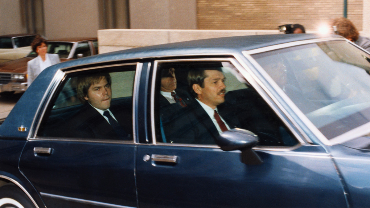 John Hinckley, Jr., accused assassinate of President Reagan, sits in the back of this motioned vehicle outside the federal court in DC shortly after asking for permission to visit his family for Easter without supervision.
