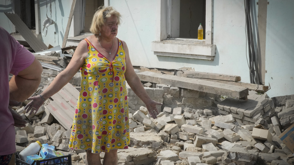 Romos ház előtt egy nő a kelet-ukrajnai Luhanszki területen fekvő Liszicsanszk ellen végrehajtott orosz légitámadás után, 2022. június 16-án.